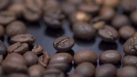 Coffee grains close-up on a dark table. Macro Stock Footage 145792934