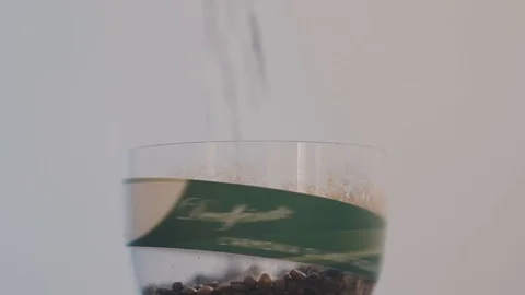 Coffee grains fall into a glass Stock Footage 76960291