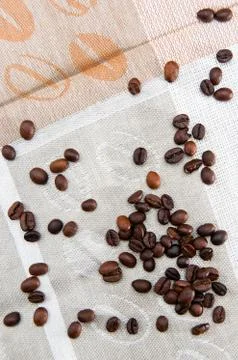Coffee grains scattered on a patterned tablecloth Stock Photos