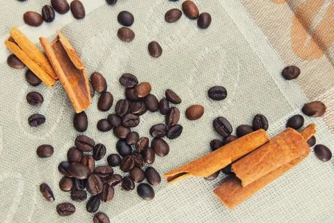 Coffee grains scattered on a patterned tablecloth Stock Photos