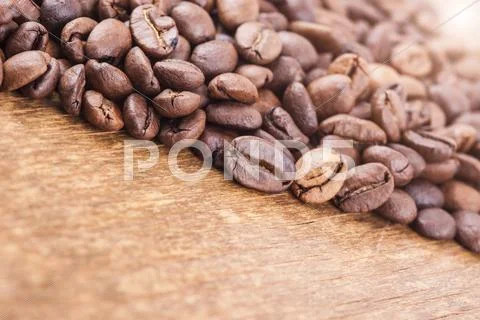 Coffee grains on wooden background. light effect in the corner Stock Photos
