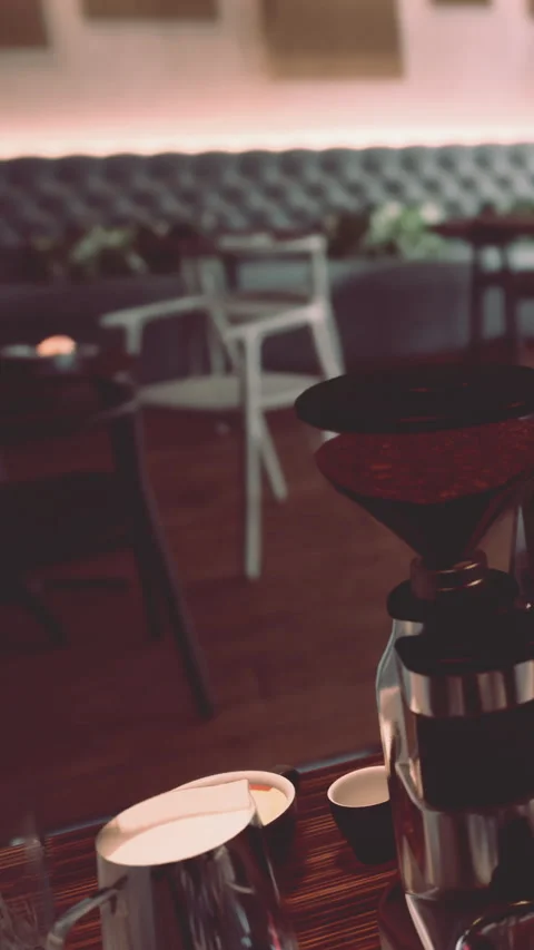 Coffee grinder sits on table in cafe with empty chairs and soft lighting Stock Footage 339108057