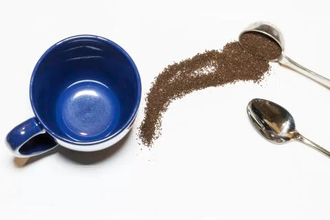 Coffee Grounds and Silver Spoon with Blue Mug Handle Out on White Background Stock Photos