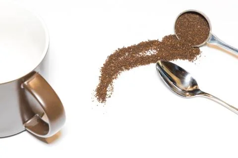 Coffee Grounds and Silver Spoon with Brown Mug Handle In and Low on White Bac Stock Photos