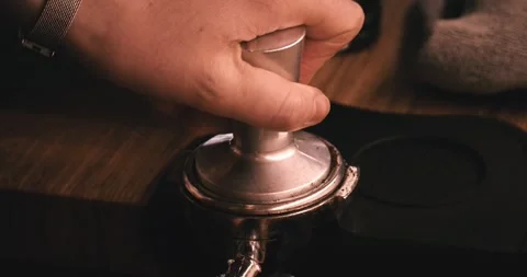 Coffee grounds are pressed into the portafilter of an coffee machine. Stock Footage 334113302
