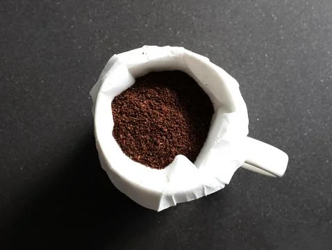 Coffee grounds in coffee with filter  on black granite counter Foto stock