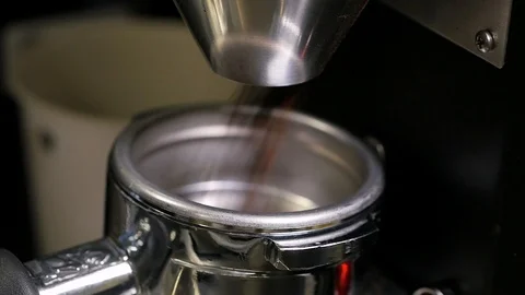 Coffee grounds shoot out of spout into measuring tool close up slow motion Stockbeeldmateriaal 93373538