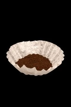 Coffee grounds in a white coffee filter on black background. 스톡 사진