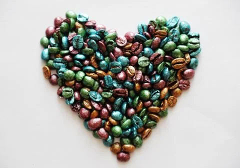 Coffee heart made of multi-colored pearl coffee beans on white background. Love Stock Photos