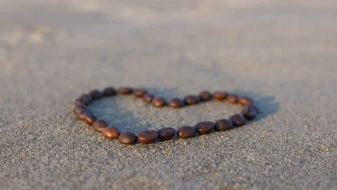 Coffee heart poured on the beach Stock Footage 86323665