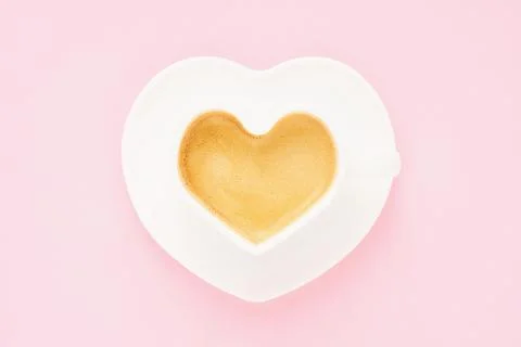 Coffee in heart shape mug on a light pink background. Valentine's day concept Stock Photos