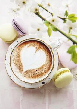 Coffee with a heart-shaped pattern and sweet macaroons desserts Stock Photos