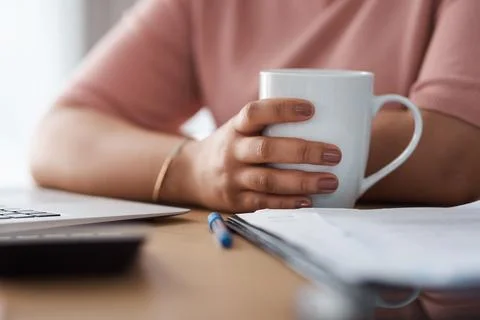 Coffee helps my brain function. Cropped shot of a woman working from home. Stock Photos