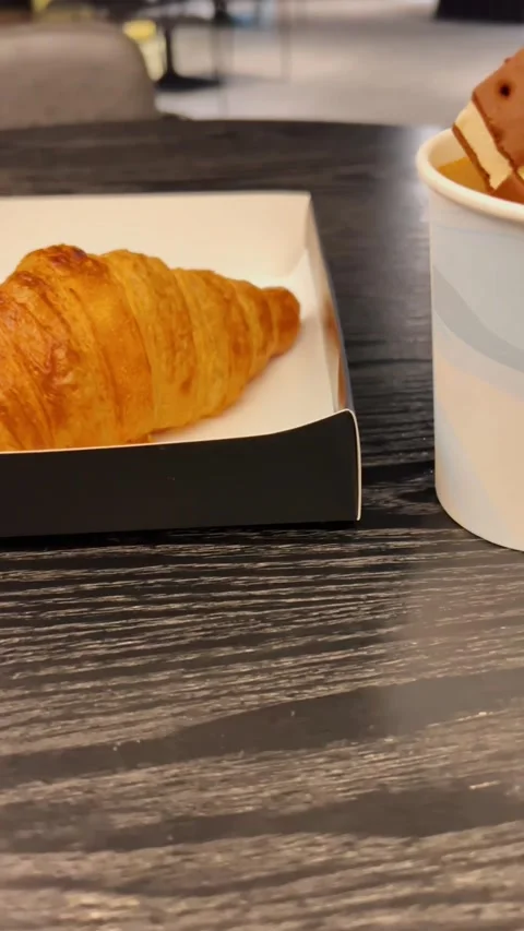 Coffee with ice cream inside and next to croisants and cafe in the backgroun Stock Footage 273109679