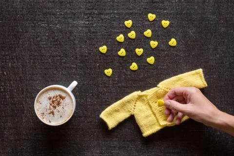 Coffee, knitting and hand with button on black Foto stock