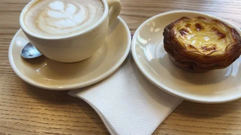Coffee latte and small crispy puff pastry basket with custard Stock Footage 339792030