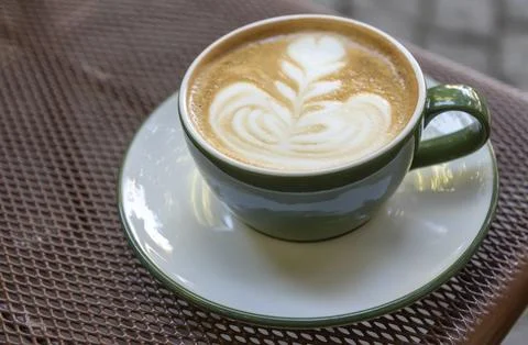 Coffee with latte art on a table in a cafe during the afternoon Stock Photos