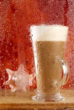Coffee latte behind rainy window, shallow dof on glass with drop Stock Photos