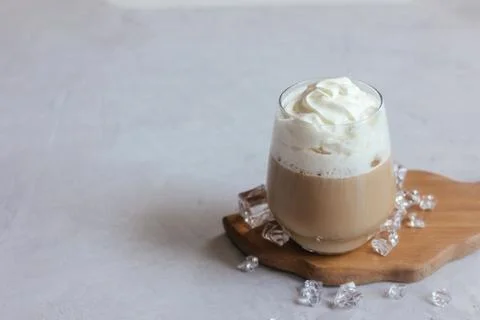 Coffee latte on a gray table in bright sunlight and free space. Cold summer.. Stock Photos