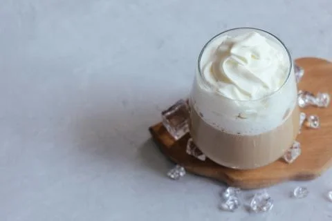 Coffee latte on a gray table in bright sunlight and free space. Cold summer.. Stock Photos