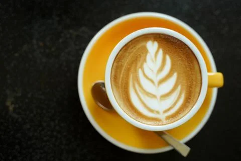 Coffee Latte leaf pattern face on black table Stock Photos