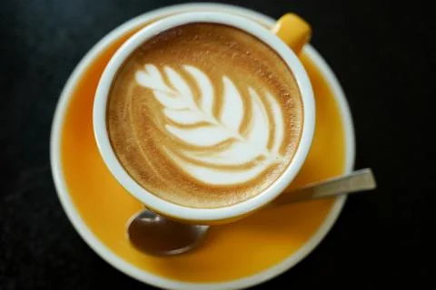 Coffee Latte leaf pattern face on black table Stock Photos