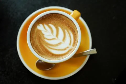 Coffee Latte leaf pattern face on black table Stock Photos
