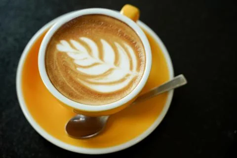 Coffee Latte leaf pattern face on black table Stock Photos