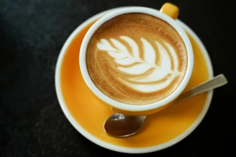 Coffee Latte leaf pattern face on black table Stock Photos