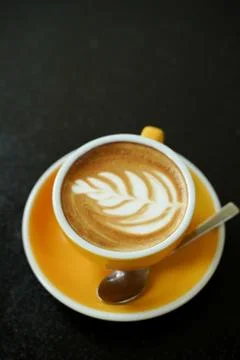 Coffee Latte leaf pattern face on black table Stock Photos
