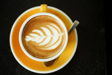 Coffee Latte leaf pattern face on black table Stock Photos