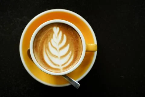 Coffee Latte leaf pattern face on black table Stock Photos