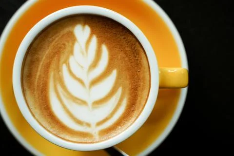 Coffee Latte leaf pattern face on black table Stock Photos