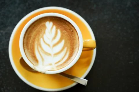 Coffee Latte leaf pattern face on black table Stock Photos