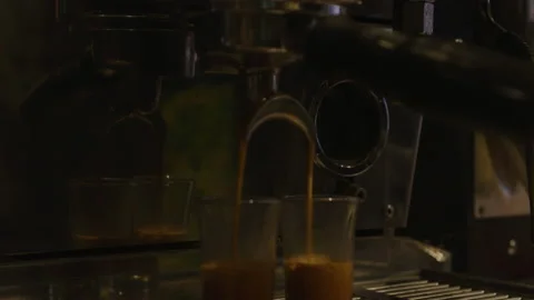 Coffee machine in cafe filling two shot glasses of espresso Stock Footage 221720407