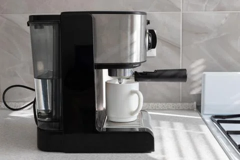 Coffee machine with a cup of coffee in the kitchen of the house Foto stock