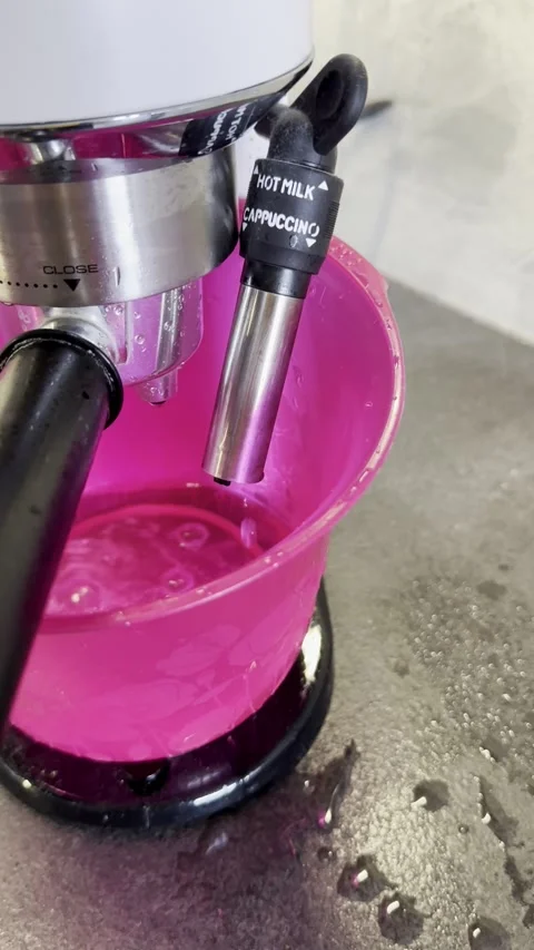 Coffee Machine Descaling Cycle Draining Water into a Pink Basin Stock Footage 340138180