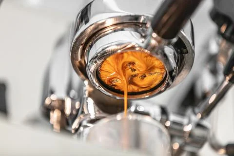 Coffee machine espresso extraction pouring from bottomless naked portafilter Stock Photos