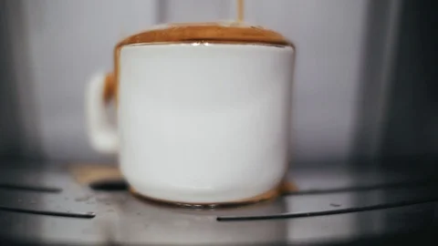 Coffee machine makes coffee in a white cup.coffee pours out of the cup Stock Footage 101182469