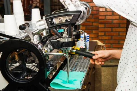 Coffee machine making coffee holded by barista arm Stock Photos