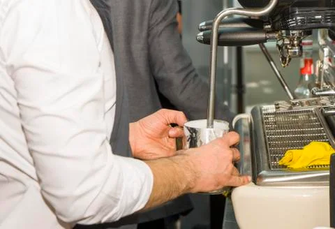 Coffee machine making coffee holded by barista arm Stock Photos