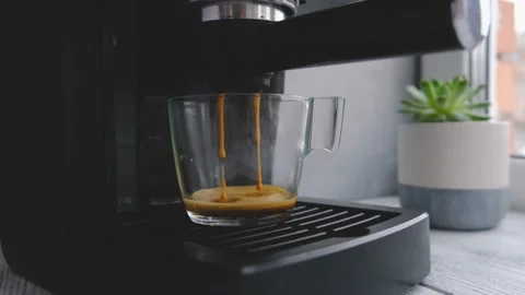 Coffee machine making espresso in glass transparent coffee cup Stock Footage 130844796