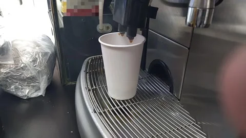 A coffee machine at a market makes takeaway coffee in a paper cup Video stock 332609769