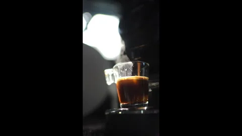 Coffee machine pouring espresso coffee into glass cup on dark background Video stock 312401724