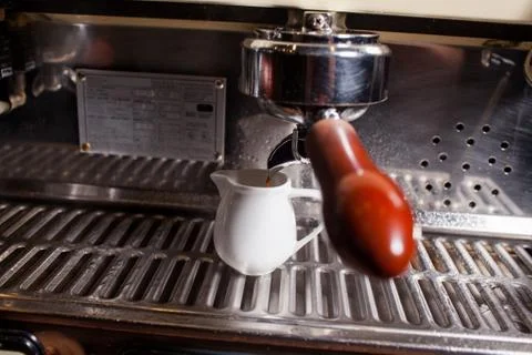 Coffee machine pouring hot coffee into porcelain mug. Close up. Stock Photos