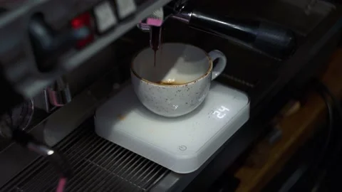 The coffee machine pours coffee into a mug on the scales. Video stock 165002303