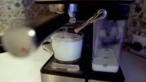 The coffee machine pours coffee into the whipped milk Stock Footage 169624946