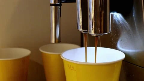 Coffee machine pours coffee into yellow paper cups, close-up process Stock Footage 172252003