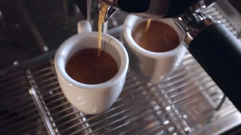 Coffee machine pours espresso into two cups Видео 200204114