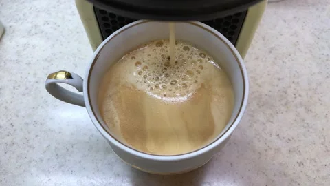 The coffee machine pours fresh brewed coffee into a white cup. Top view Stock Footage 229071819